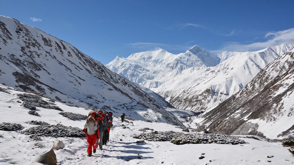 Trekkers walking towards the snow-covered Annapurna Base Camp sanctuary, Nepal